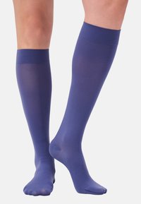 Calze al ginocchio in un blu scuro uniforme, realizzate in un materiale liscio e trasparente con una fascia testurizzata nella parte superiore, dotate di una punta chiusa.