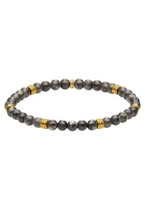 Bracelet extensible avec des perles gris foncé polies et de petits anneaux dorés répartis uniformément autour du cercle.
