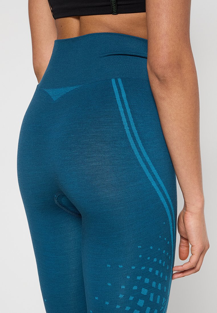 Legginsy sportowe w kolorze niebiesko-zielonym o wysokim stanie, o gładkiej teksturze, z kontrastującymi niebieskimi paskami i kropkowanym wzorem na dolnej części nogawki.