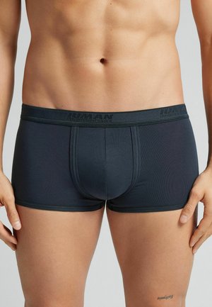 Dunkelgraue Boxer-Shorts aus stretchigem Material, mit einem markierten Bund und einer engen Passform, die sichtbare Nahtdetails aufweisen.