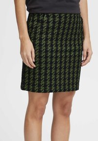 Zwarte rok met groen houndstooth patroon, knielang, met een gestructureerde stof, aansluitende stijl, voorzien van een gladde tailleband en zonder zichtbare hardware.