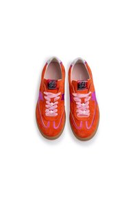 Oranssi samettikangaslenkkarit, joissa on vaaleanpunaisia yksityiskohtia, sisältäen vaaleanpunaiset nauhat, joissa on helmiä. Klassinen muotoilu, jossa on teksturoitu pohja ja logotagi.