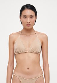 Stripet bikini-set med trekantet halterneck-top med justerbare bånd og matchende lavt midje-bunn, vist i en lys brun og kremfarget fargekombinasjon.