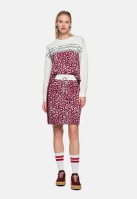 Sweatshirt- und Rock-Set, weiß und burgunderrot mit Leopardenmuster, mit Kordelzug in der Taille und gestreiften Akzenten an den Socken.