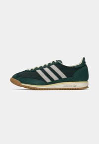 Green suede and mesh sneaker with white stripes and cream laces. Gum rubber outsole and textured upper. Classic athletic design.