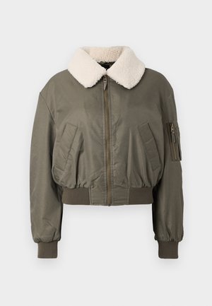 Jachetă bomber scurtă, de culoare verde măslinie, cu un guler pufos alb, închidere cu fermoar, buzunare laterale și manșete ribbate. Textură netedă.