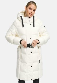 Witte pufferjas met een capuchon, voorzien van zwarte knopen en bandjes, een taille met riem, en een zachte vachtachtige textuur aan de zijkanten.