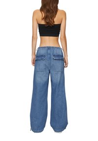 Blauwe denim wijde broek met een elastische tailleband, twee grote achterzakken en rafelige zomen voor een relaxte pasvorm.