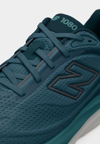 Αθλητικό παπούτσι σε τιρκουάζ χρώμα με υφασμάτινη υφή, κορδόνια που διασταυρώνονται, χυτές τρύπες και ανάγλυφο λογότυπο της μάρκας στο πλάι και στη γλώσσα.