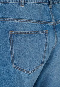 Vaqueros de mezclilla azul claro con un solo bolsillo trasero con costuras naranjas, textura visible y un corte estándar.