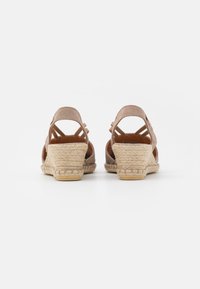 Sandalias de cuña de ante marrón con tacón de yute trenzado, diseño de espalda abierta y correas entrelazadas para un ajuste seguro.