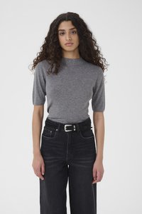 Γκρι μπλουζάκι με κοντά μανίκια και στρογγυλή λαιμόκοψη, συνδυασμένο με μαύρο τζιν παντελόνι φαρδιάς γραμμής και ψηλόμεσο, και μαύρη ζώνη με ασημένια αγκράφα.