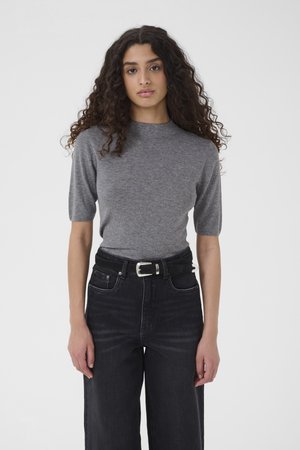 Γκρι μπλουζάκι με κοντά μανίκια και στρογγυλή λαιμόκοψη, συνδυασμένο με μαύρο τζιν παντελόνι φαρδιάς γραμμής και ψηλόμεσο, και μαύρη ζώνη με ασημένια αγκράφα.