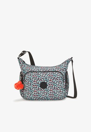 Multicolored fabric shoulder bag with a patterned design, a front zip pocket, and a detachable orange pom-pom keychain.