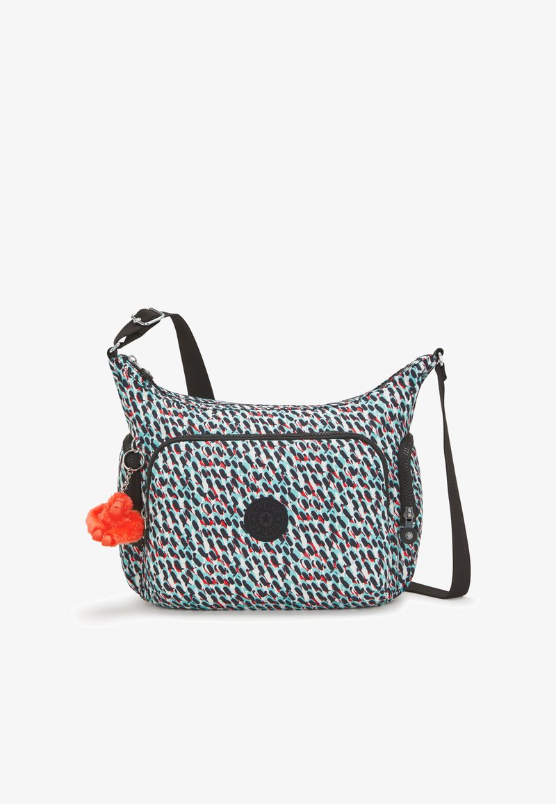 Multicolored fabric shoulder bag with a patterned design, a front zip pocket, and a detachable orange pom-pom keychain.