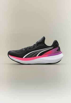 Zapatilla de running negra con logo blanco de Puma, acentos en rosa y púrpura en la entresuela, suela acolchada blanca con la etiqueta "PROFOAM", vista lateral sobre fondo neutro.