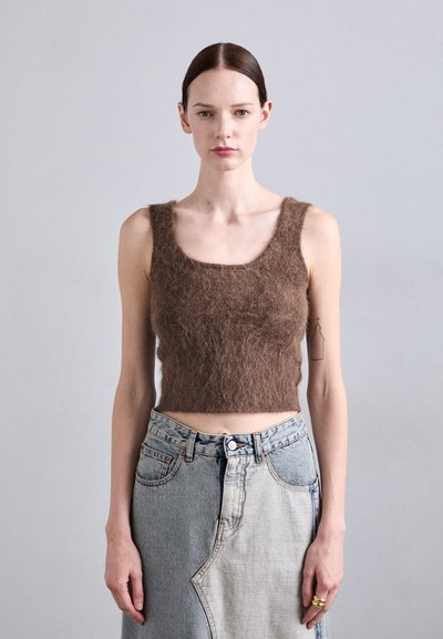 Brown fluffy cropped tank top with wide straps, paired with a light blue, two-toned denim skirt featuring an asymmetrical design and silver hardware.
