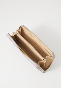 Portafoglio grigio con zip dorata, interno beige, diverse fessure per carte e scomparto per monete con zip. Texture esterna liscia.