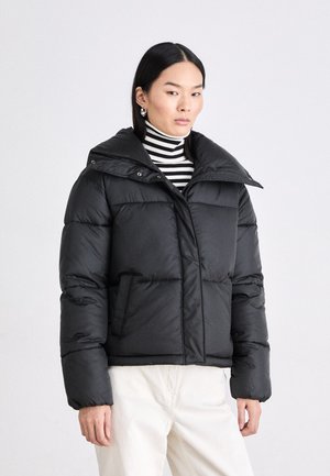 Fekete puff Jackets széles gallérral, elöl gombos záródással, két elülső zsebbel és könnyű, steppelt textúrával.