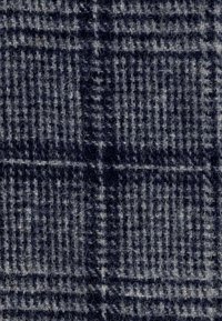 Tela de lana con un patrón de cuadros en azul oscuro y gris claro, que presenta texturas distintas y una superficie suave y peluda.