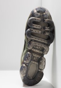 Suola di scarpa sportiva con ammortizzazione in gomma trasparente, caratterizzata da un motivo testurizzato e bordi rinforzati in tonalità di grigio e verde oliva.
