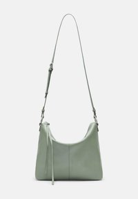 Miętowo-zielona skórzana torebka na ramię o miękkim, zaokrąglonym kształcie, z regulowanym paskiem i subtelnie wytłoczonym logo po jednej stronie.
