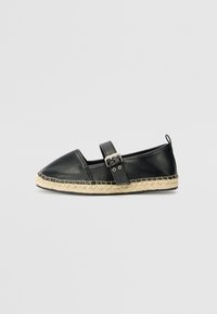 Zwarte leren espadrille met een ronde neus, enkelbandje en gevlochten jute zool. Beschikt over een gestikte accentrand.