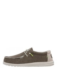 Zapatos tipo slip-on hechos de tela marrón tejida, con costuras y detalles en blanco, suela blanca y detalles en verde claro en la parte superior.