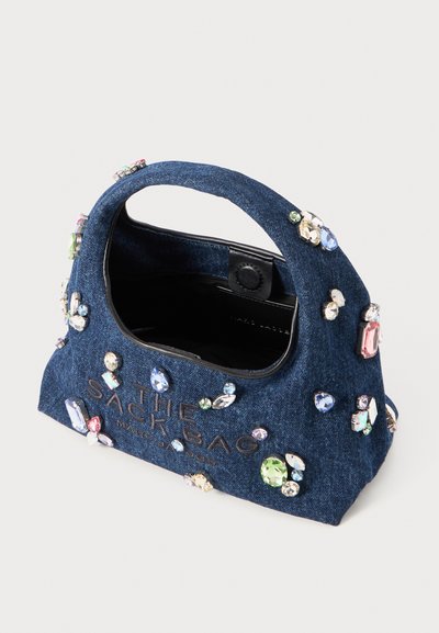 Denim-käsilaukku, jossa on pyöreä kahva, koristeena värikkäät jalokivet; sisältää mustan sisustan ja kohokuvioidun tekstin edessä.