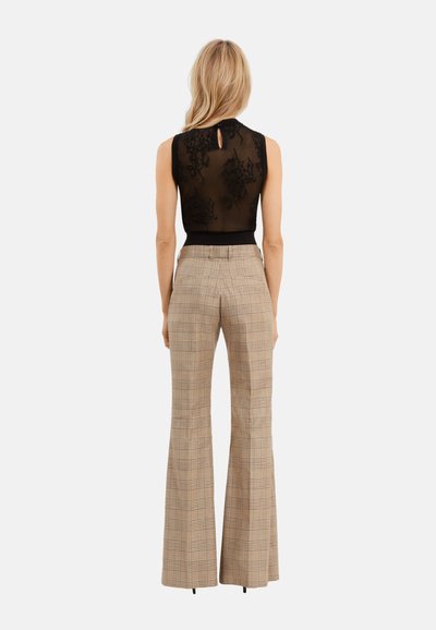 Top sans manches noir avec des détails en dentelle, associé à un pantalon évasé beige à carreaux taille haute, offrant une coupe ajustée et une texture lisse.