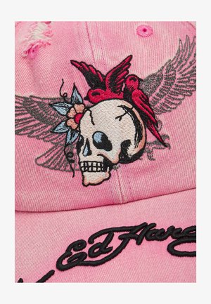 Roze pet met een geborduurde schedel met vleugels, rode vogels, een bloem en zwarte cursieve tekst op de klep.