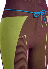 Close-up van leggings in pruim met groene accenten, met een textuur patroon en een blauwe trekkoord met groene uiteinden bij de taille.
