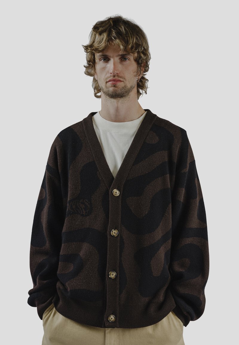 Brauner Cardigan mit einem schwarzen abstrakten Muster, mit V-Ausschnitt, fünf Knöpfen vorne und gerippten Bündchen sowie Saum.