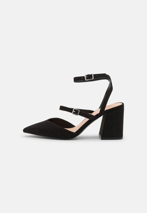 Czarne zamszowe szpilki z wąskim noskiem, z dwiema klamrami na kostkach i grubym obcasem. Gładka tekstura z matowym wykończeniem i neutralnym wnętrzem.