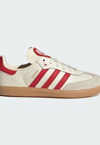 Sneakers met een bovenwerk van wit leer, rode accenten, drie rode strepen, een rode tongpatch en een gumrubberen zool. Beschikt over een suède neus en merknaam.