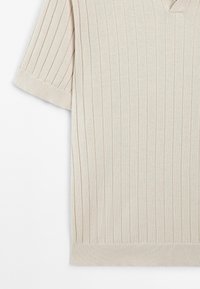 Haut en tricot beige à manches courtes avec nervures verticales et col en V, doté d'un ourlet ajusté et de manches retroussées.