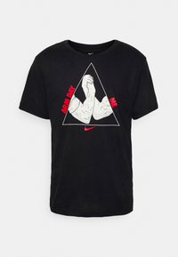 Camiseta de algodón negra con manga corta que presenta un gráfico de brazos flexionados dentro de un contorno triangular y el texto "ARM DAY ME" en acentos rojos.