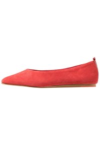Chaussure plate en daim rouge avec un bout pointu, au design minimaliste, texture douce et semelle à profil bas. Pas de quincaillerie ni de motifs visibles.