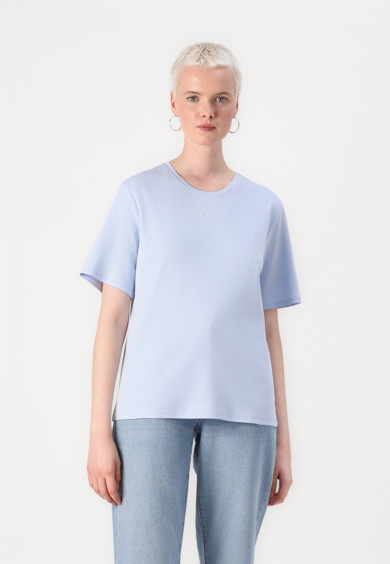 Light blue t-shirt with a round neckline and short sleeves. Features subtle embroidered logo at the chest. Soft fabric and relaxed fit.