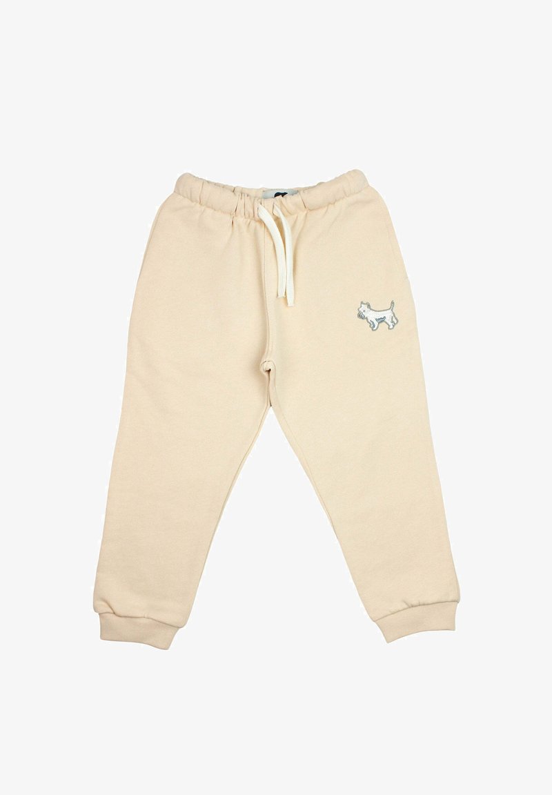 Beige peuter joggingsbroek met elastische taille, witte trekkoord, afgeknelde enkelbanden en een kleine hondenborduring op het rechterbeen.
