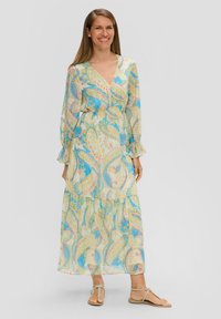Maxikleid aus leichtem, transparentem Stoff mit einem blau-gelben Paisleymuster. Verfügt über lange Ärmel, einen V-Ausschnitt und einen gestuften Rock.
