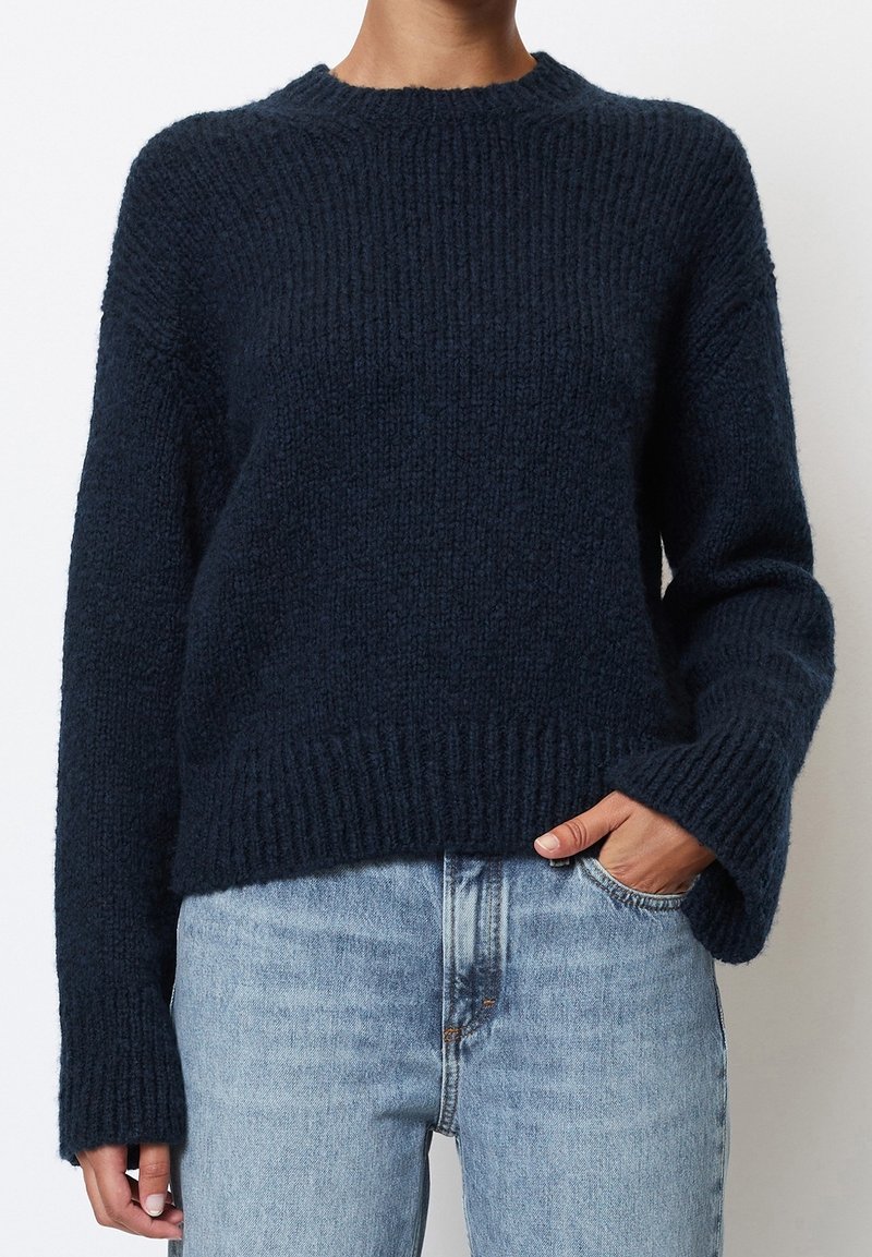 Dunkelblauer Strickpullover mit gerippter Textur, Rundhalsausschnitt und überschnittenen Schultern. Verfügt über lange Ärmel und eine lässige Passform in der Taille.