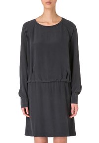 Grå, långärmad klänning i ett mjukt tyg. Har en rund halsringning och ett elastiskt midjeband för en avslappnad passform. Enkel, lös design.