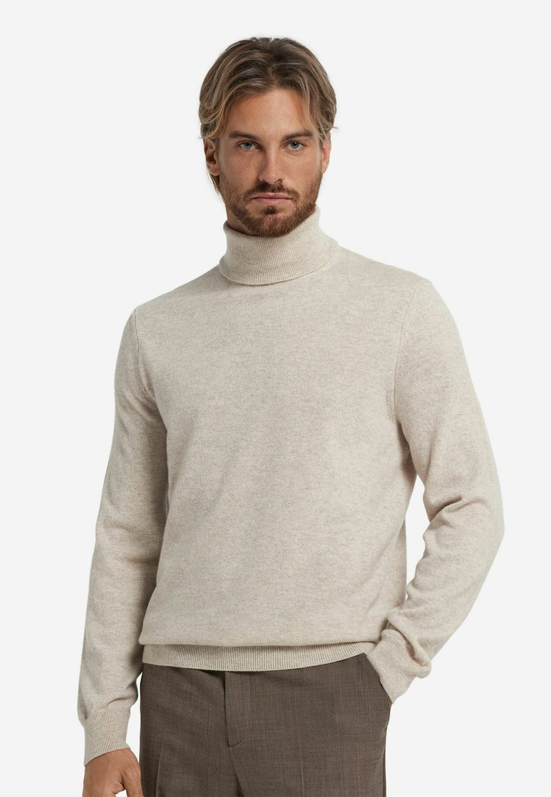 Jasno beżowy sweter typu golf w miękkiej dzianinie, charakteryzujący się dopasowanym krojem, długimi rękawami oraz prążkowanymi mankietami i dolnym wykończeniem.