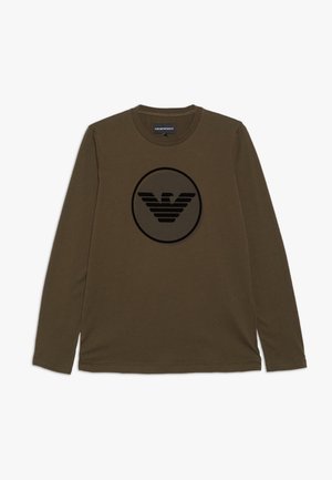 Zielona oliwkowa koszulka z długim rękawem, wykonana z bawełny, z dużym czarnym logo orła w kole na środku. Gładka tekstura, fason z okrągłym dekoltem.