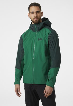 Chaqueta impermeable verde con capucha, mangas oscuras en contraste, cierre frontal con cremallera y un pequeño logo impreso en el pecho.