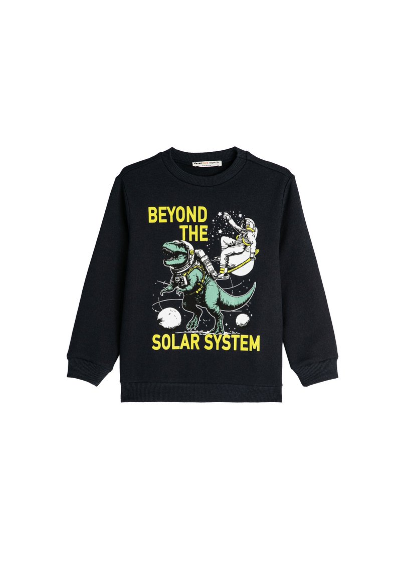 Sudadera negra con un gráfico de un dinosaurio verde y un astronauta, con el texto " MÁS ALLÁ DEL SISTEMA SOLAR " en amarillo.