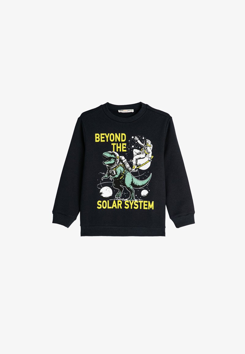 Svart sweatshirt med en grafisk bild av en grön dinosaurie och en astronaut, med texten "BEYOND THE SOLAR SYSTEM" i gult.