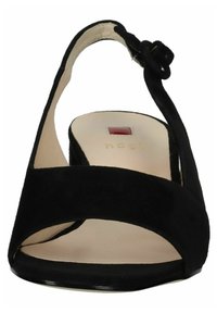Sandal con tacco in suede nero, con punta aperta, fasce incrociate e cinturino alla caviglia regolabile. Interno beige liscio e suola nera.