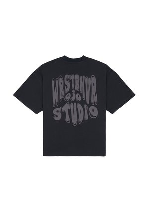 T-shirt nera oversize con stampa grafica che recita "WRSTBHVR 030 STUDIO" in lettere ondulate di colore grigio chiaro sul retro. Collo tondo regolare.